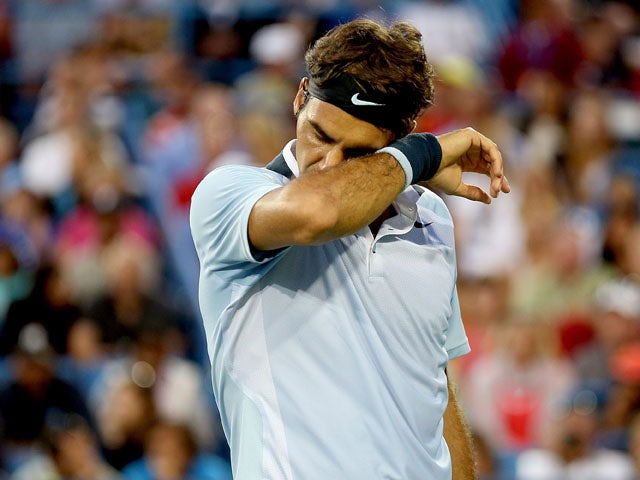 Roger Federer of Switzerland wipes his face between points while playing Rafael Nadal of Spain during the Western & Southern Open on August 16, 2013