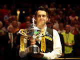 Ronnie O'Sullivan of England poses with the trophy and his son Ronnie after beating Barry Hawkins of England to win the Betfair World Snooker Championship at the Crucible Theatre on May 6, 2013