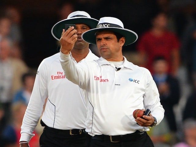 Umpire Aleem Dar takes a light reading on day five of the fifth Ashes test on August 25, 2013