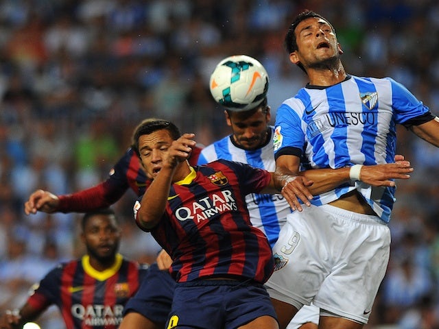 Players from Barcelona and Malaga battle for the ball during a game on August 25, 2013