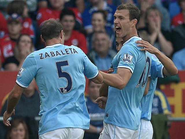 Manchester City's Edin Dzeko is congratulated by team mates after scoring the opening goal against Cardiff on August 25, 2013