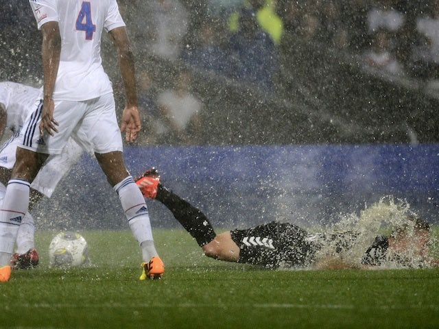 Reims forward Gaetan Courtet slides in the rain against Lyon on August 24, 2013