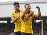 Arsenal's Lukas Podolski celebrates with team mate Olivier Giroud after scoring his team's third goal against Fulham on August 24, 2013