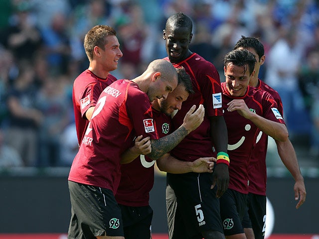 Hannover's Szabolcs Huszti is congratulated by team mates after scoring the opening goal against Schalke on August 24, 2013