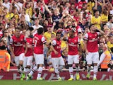 Arsenal's French striker Olivier Giroud celebrates with teammates after scoring the opening goal of the English Premier League football match between Arsenal and Tottenham Hotspur at the Emirates Stadium in London on September 1, 2013