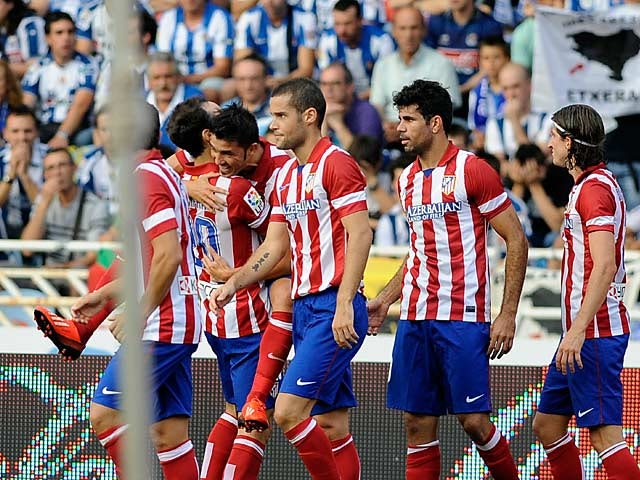 Atletico Madrid's David Villa is congratulated by team mates after scoring his team's opening goal against Real Sociedad on September 1, 2013
