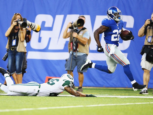 David Wilson #22 of the New York Giants scores against Dawan Landry #26 of the New York Jets during their pre season game at MetLife Stadium on August 24, 2013