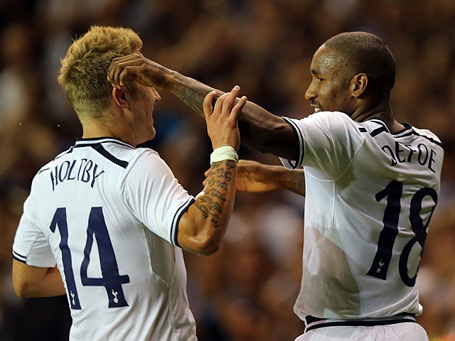 Spurs' Jermain Defoe is congratulated by team mate Lewis Holtby after scoring then opening goal against Dinamo Tbilisi during their Europa League play-off match on August 29, 2013