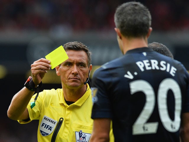 Referee Andre Marriner shows a Yellow card to Manchester United's Dutch striker Robin van Persie during the English Premier League football match between Liverpool and Manchester United at the Anfield stadium in Liverpool on September 1, 2013