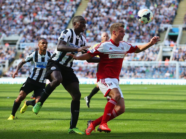 Mapou Yanga-Mbiwa of Newcastle United challenges for the ball with Alex Kacaniklic of Fulham during the Barclays Premier League match between Newcastle United and Fulham at St James' Park on August 31, 2013