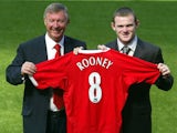 Sir Alex Ferguson and Wayne Rooney pose with the latter's shirt at his Manchester United unveiling.