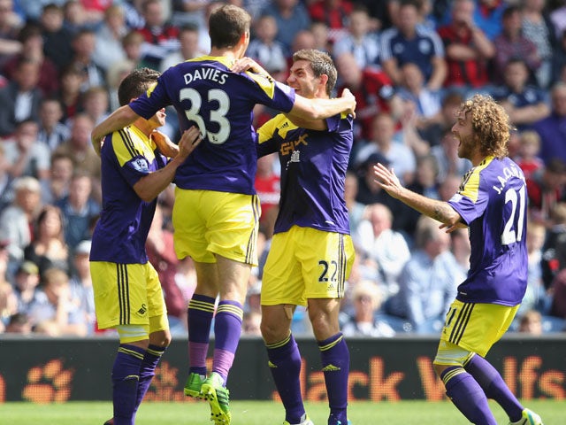 Ben Davies of Swansea City celebrates with team mates after scoring the first goal during the Barclays Premier League match between West Bromwich Albion and Swansea City at The Hawthorns on September 01, 2013