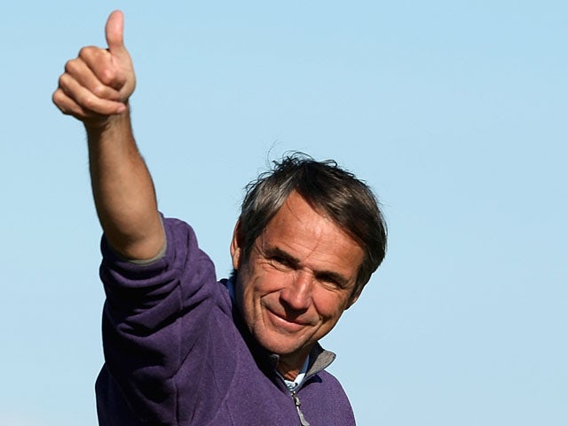 Football pundit Alan Hansen waves to Ruud Gullit and Jamie Redknapp on the stands on the 17th green during the final round of The Alfred Dunhill Links Championship at The Old Course on October 7, 2012