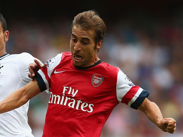 Nacer Chadli of Spurs and Mathieu Flamini of Arsenal battle for the ball during the Barclays Premier League match between Arsenal and Tottenham Hotspur at Emirates Stadium on September 01, 2013
