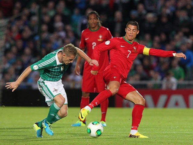 Cristiano Ronaldo vies for the ball with Northern Ireland's Steven Davis during the 2014 World Cup European zone group F qualifying football match between Northern Ireland and Portugal at Windsor Park in Belfast, Northern Ireland, on September 6, 2013