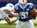 Donald Brown of the Indianapolis Colts runs the ball as Nolan Carroll of the Miami Dolphins reaches for the tackle at Lucas Oil Stadium on September 15, 2013
