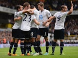 Tottenham's Gylfi Sigurosson is congratulated by team mates after scoring the opening goal against Norwich City on September 14, 2013