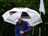 Justin Rose shelters himself from the rain at the BMW Championship on September 15, 2013