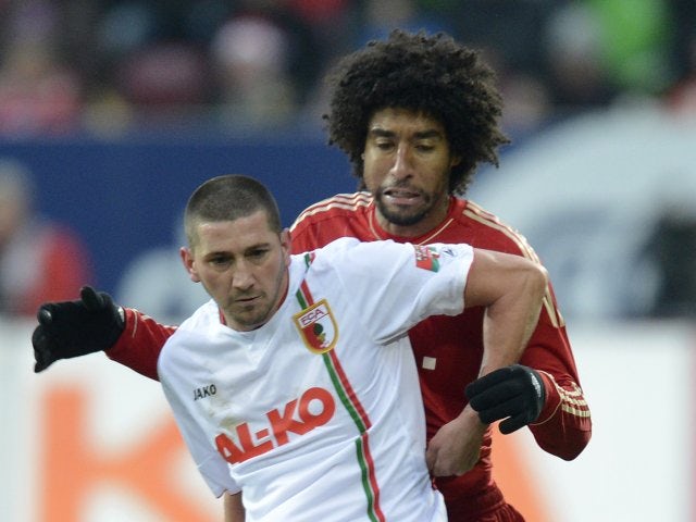 Augsburg striker Sascha Molders holds off a challenge from Bayern Munich defender Dante.