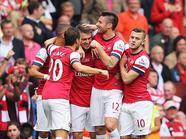 Arsenal's Aaron Ramsey is congratulated by teammates after scoring the opening goal against Stoke during their Premier League match on September 22, 2013