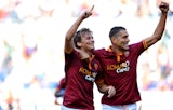Roma's Adem Ljajic celebrates with teammate Marco Borriello after scoring his team's second goal against Lazio during their Serie A match on September 22, 2013