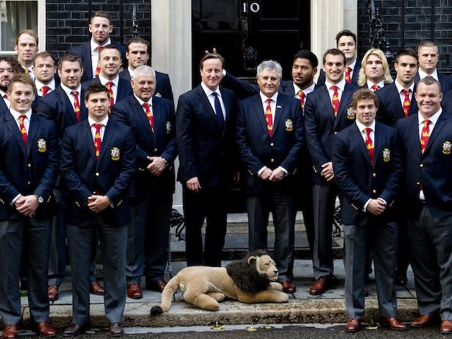 Prime Minister David Cameron poses with the British and Irish Lions rugby squad, with Manu Tuilagi making a gesture behind the PM on September 16, 2013