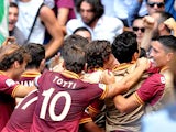 Roma's Federico Balzaretti is mobbed by teammates after scoring the opening goal against Lazio during their Serie A match on September 22, 2013