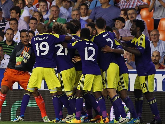 Swansea's Jonathan de Guzman is mobbed by team mates after scoring his team's third goal against Valencia during their Europa League group match on September 19, 2013