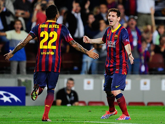 Barcelona's Lionel Messi is congratulated by team mate Dani Alves after scoring the opening goal against Ajax during their Champions League group match on September 18, 2013