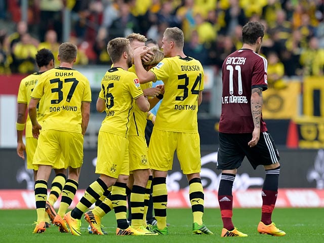 Dortmund's Marcel Schmelzer is congratulated by team mates after scoring the opening goal against Nuremberg during their Bundesliga match on September 21, 2013