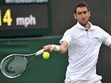 Marin Cilic returns against Marcos Baghdatis on his way to victory in their men's first round match at Wimbledon on June 24, 2013