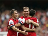 Arsenal's Per Mertesackeris congratulated by teammates Aaron Ramsey and Mesut Ozil after scoring his team's second goal against Stoke during their Premier League match on September 22, 2013