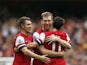 Arsenal's Per Mertesackeris congratulated by teammates Aaron Ramsey and Mesut Ozil after scoring his team's second goal against Stoke during their Premier League match on September 22, 2013