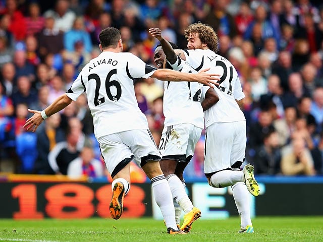 Swansea's Nathan Dyer celebrates with teammates Alvaro Vazquez and Jose Alberto Canas after scoring his team's second goal against Crystal Palace during their Premier League match on September 22, 2013