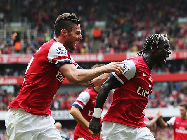 Arsenal's Bacary Sagna is congratulated by teammate Olivier Giroud after scoring his team's third goal against Stoke during their Premier League match on September 22, 2013