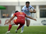 Racing's British centre Jamie Roberts tries to avoid the tackle of Perpignan's French N°8 Karl Chateau on September 8, 2013