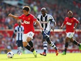 Shinji Kagawa of Manchester United breaks free from Youssuf Mulumbu of West Bromwich Albion during the Barclays Premier League match between Manchester United and West Bromwich Albion at Old Trafford on September 28, 2013