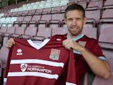 New Northampton Town signing Paul Reid poses with a shirt during a photo call at Sixfields Stadium on September 27, 2013