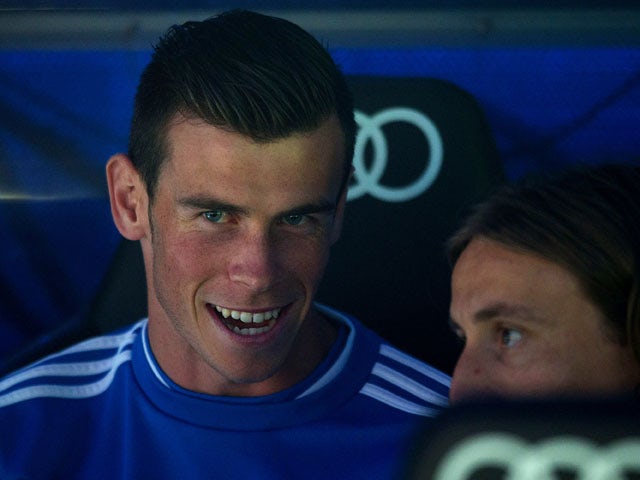 Gareth Bale of Real Madrid CF sits on the bench as he speaks with team-mate Luka Modric prior to start the La Liga match between Real Madrid CF and Club Atletico de Madrid at Estadio Santiago Bernabeu on September 28, 2013