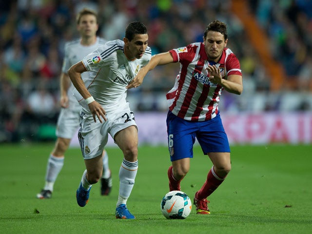 Angel Di Maria of Real Madrid CF competes for the ball with Koke of Atletico de Madrid during the La Liga match between Real Madrid CF and Club Atletico de Madrid at Estadio Santiago Bernabeu on September 28, 2013