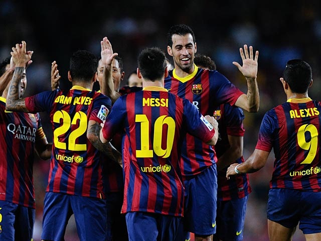 Barcelona's Sergio Busquets is congratulated by teammates after scoring his team's third goal against Real Sociedad during their La Liga match on September 24, 2013