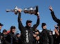 Oracle Team USA tactician Sir Ben Ainslie holds the America's Cup trophy as he celebrates onstage after they beat Emirates Team New Zealand to defend the America's Cup during the final race on September 25, 2013