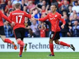 Peter Odemwingie of Cardiff City (R) celebrates with team-mate Aron Gunnarsson after scoring a goal during the Barclays Premier League match between Cardiff City and Newcastle United at Cardiff City Stadium on October 5, 2013