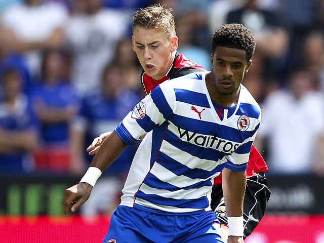 Gareth McCleary of Reading holds off the challenge of Elliot Hewitt of Ipswich during the Sky Bet Championship match between Reading and Ipswich Town at the Madejski Stadium on August 03, 2013