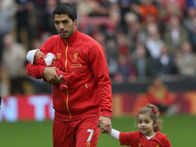 Luis Suarez of Liverpool with his new baby and daughter prior to the Barclays Premier League match between Liverpool and Crystal Palace at Anfield on October 5, 2013