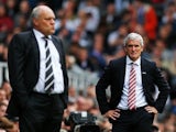 Fulham manager Mark Hughes looks on as Stoke boss Martin Jol watches the Barclays Premier League game between their sides on October 5, 2013