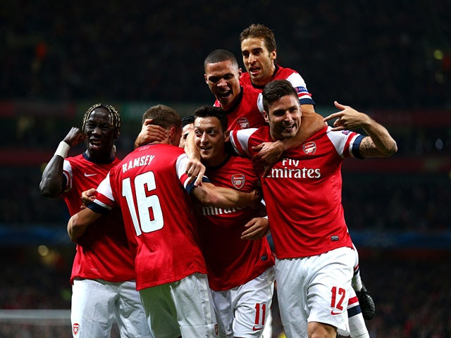Arsenal's Mesut Ozil is congratulated by teammates after scoring the opening goal against Napoli during their Champions League group match on October 1, 2013