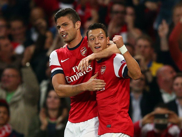 Arsenal's Olivier Giroud celebrates with team mate Mesut Ozil after scoring his team's second goal against Napoli during their Champions League group match on October 1, 2013