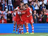 Adam Lallana of Southampton celebrates with team mates as he scores their first goal during the Barclays Premier League match between Southampton and Swansea City at St Mary's Stadium on October 6, 2013