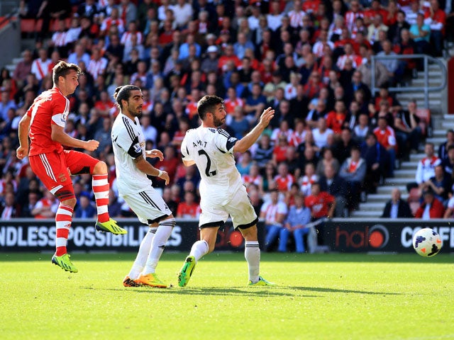 Jay Rodriguez of Southampton shoots past Chico Flores and Jordi Amat of Swansea City to score their second goal during the Barclays Premier League match between Southampton and Swansea City at St Mary's Stadium on October 6, 2013